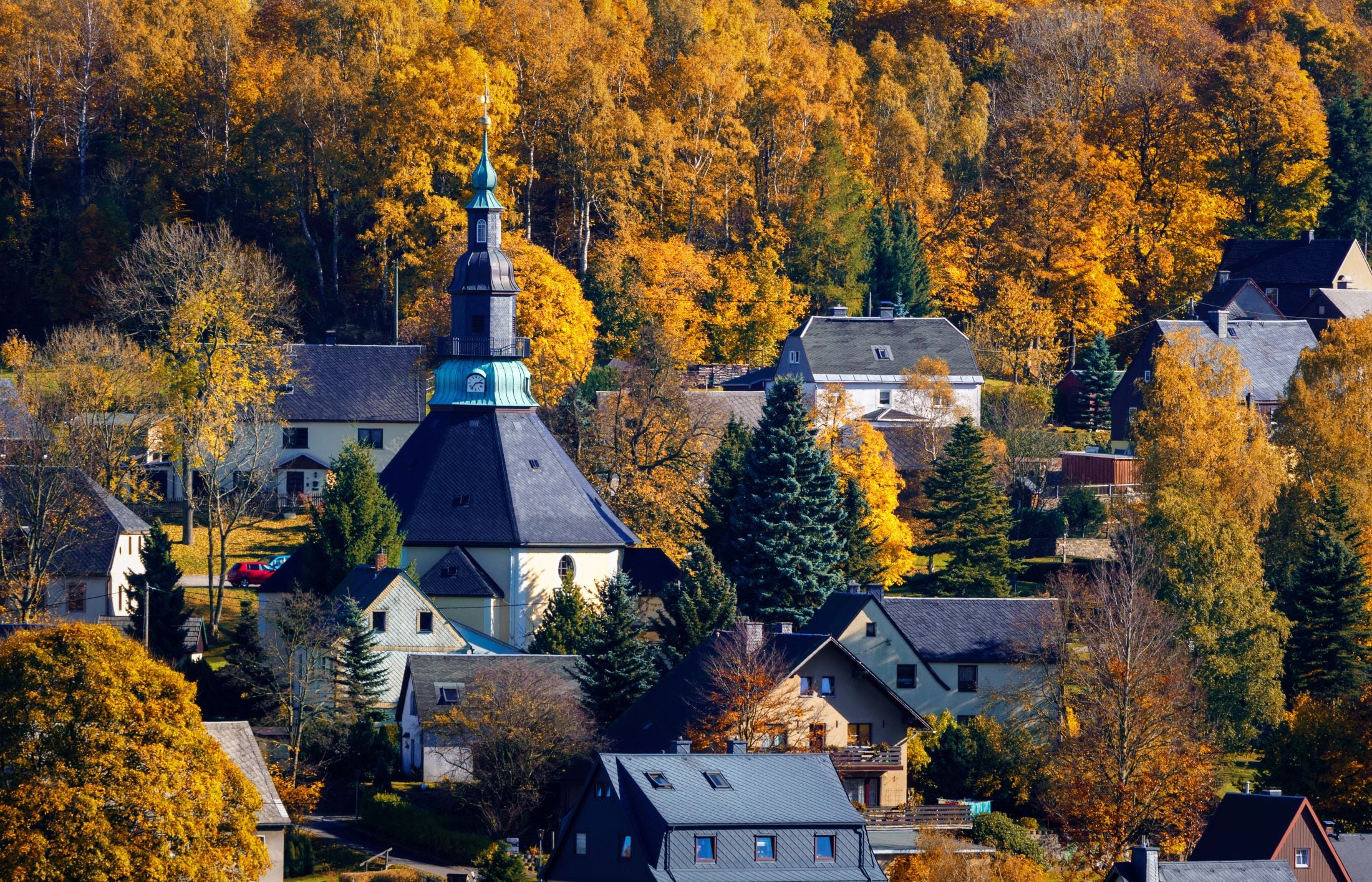 Blick auf den Kurort Seiffen mit der Bergkirche und den bewaldeten Höhen des Erzgebirges