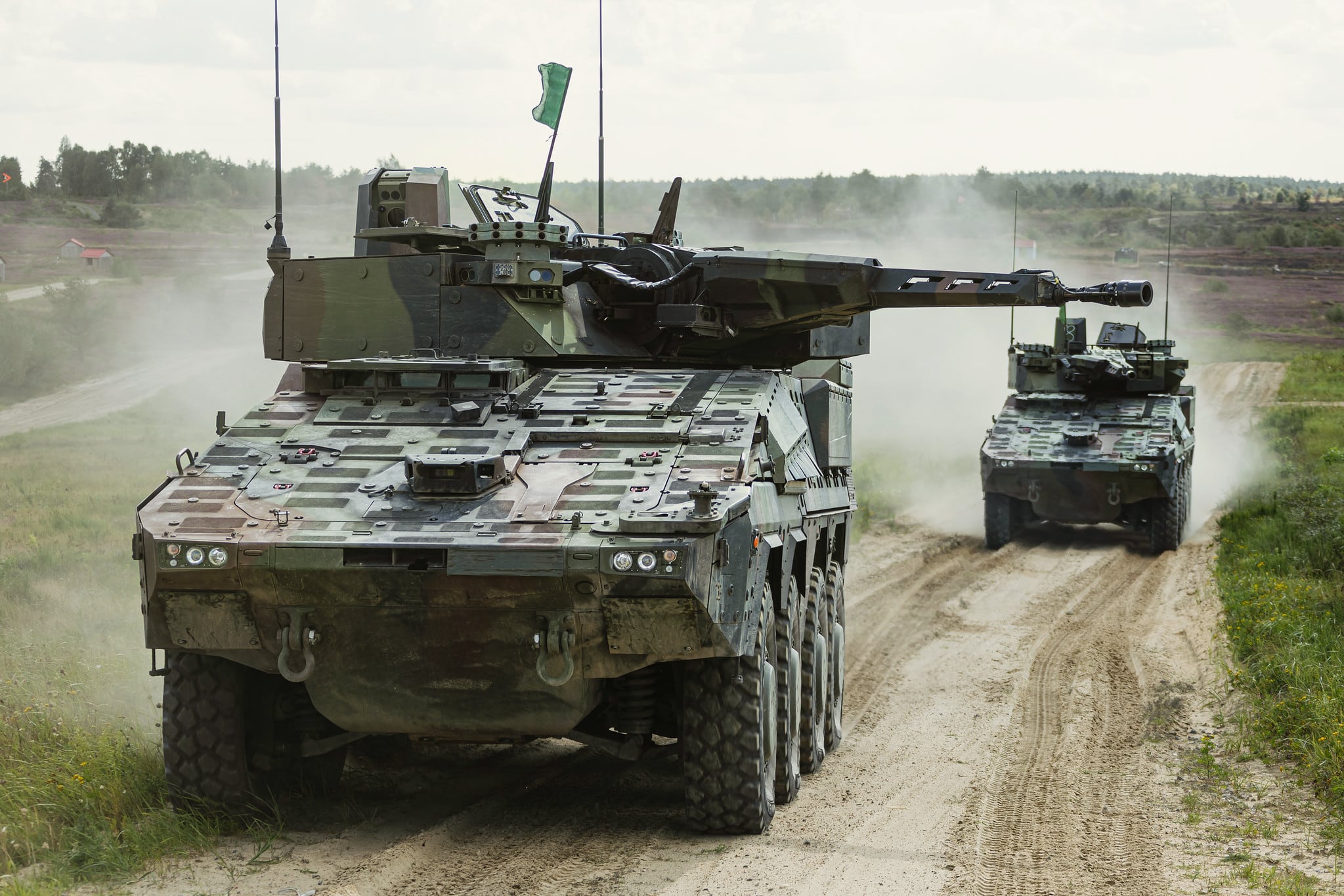 Zwei Radpanzer Schwerer Waffenträger Infanterie rollen in ihre Feuerstellung während der Industrieausbildung durch Rheinmetall auf dem Truppenübungsplatz